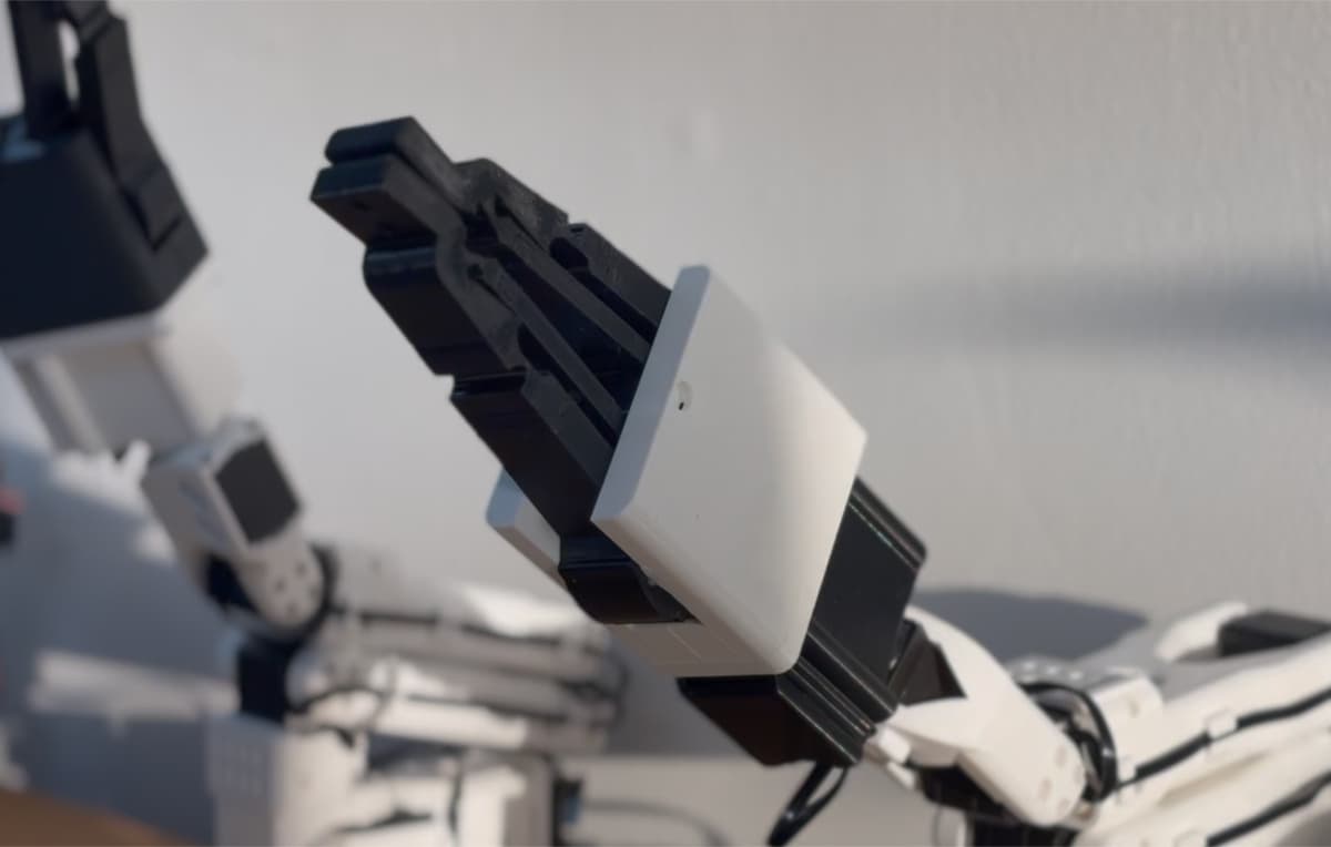 Small Nibbler v1.0 mounted on a white SO-101 arm in sunlight.